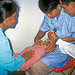 Agentes de saúde examinam um bebê no. CAMBOJA