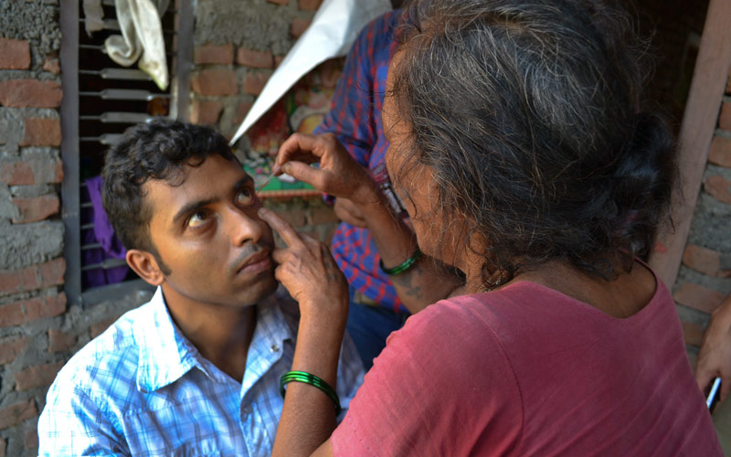Un agent bénévole de santé communautaire applique de la fl uorescéine pour détecter les érosions de cornée. NÉPAL. JESSICA KIM