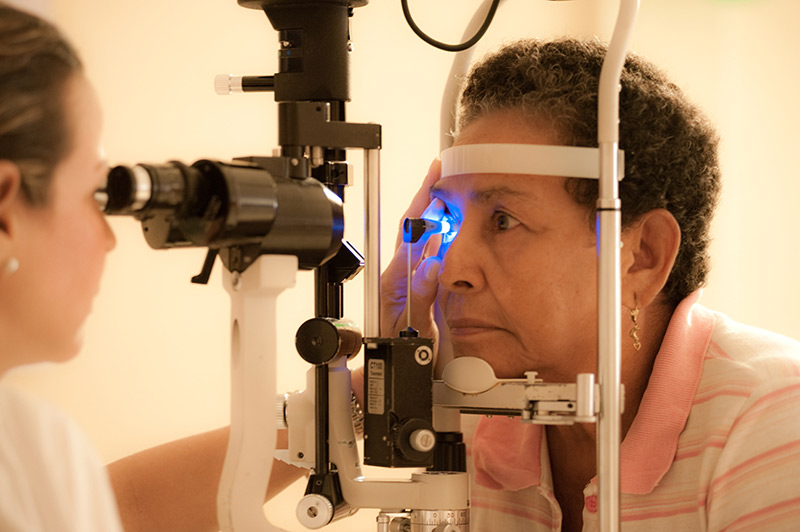 A female ophthalmologist measuring the pressure of a female patient's right eye at the slit lamp